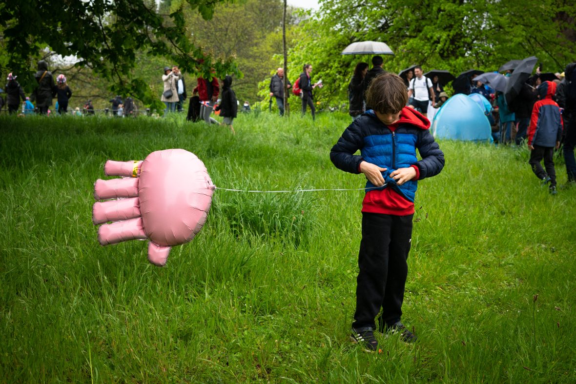 A child in the park holding a helium balloon.
